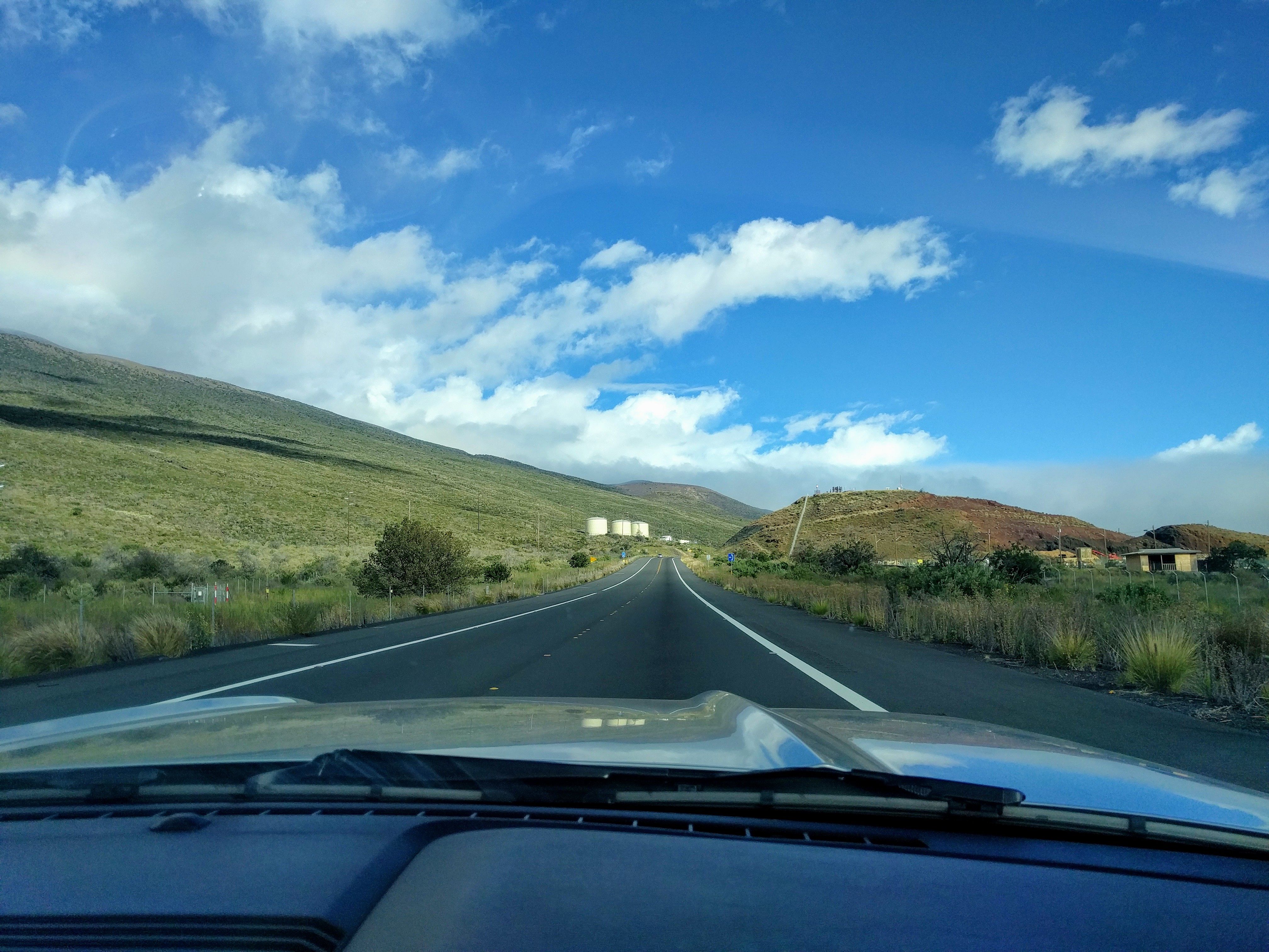 View of the road and mountains through car windshield.